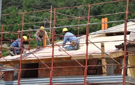 roofers installing underlayment on a sloped roof