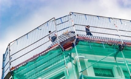 roofers on steep slope roof with guard rail fencing for fall protection