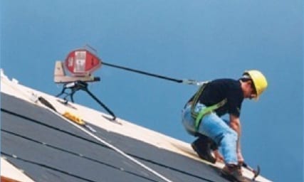 roofer using a harness while installing roof underlyment