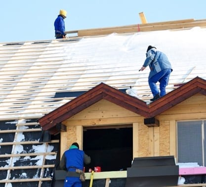 roofers working on snow-covered roof