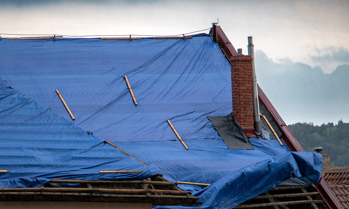 large tarp covering a section of a roof due to rain