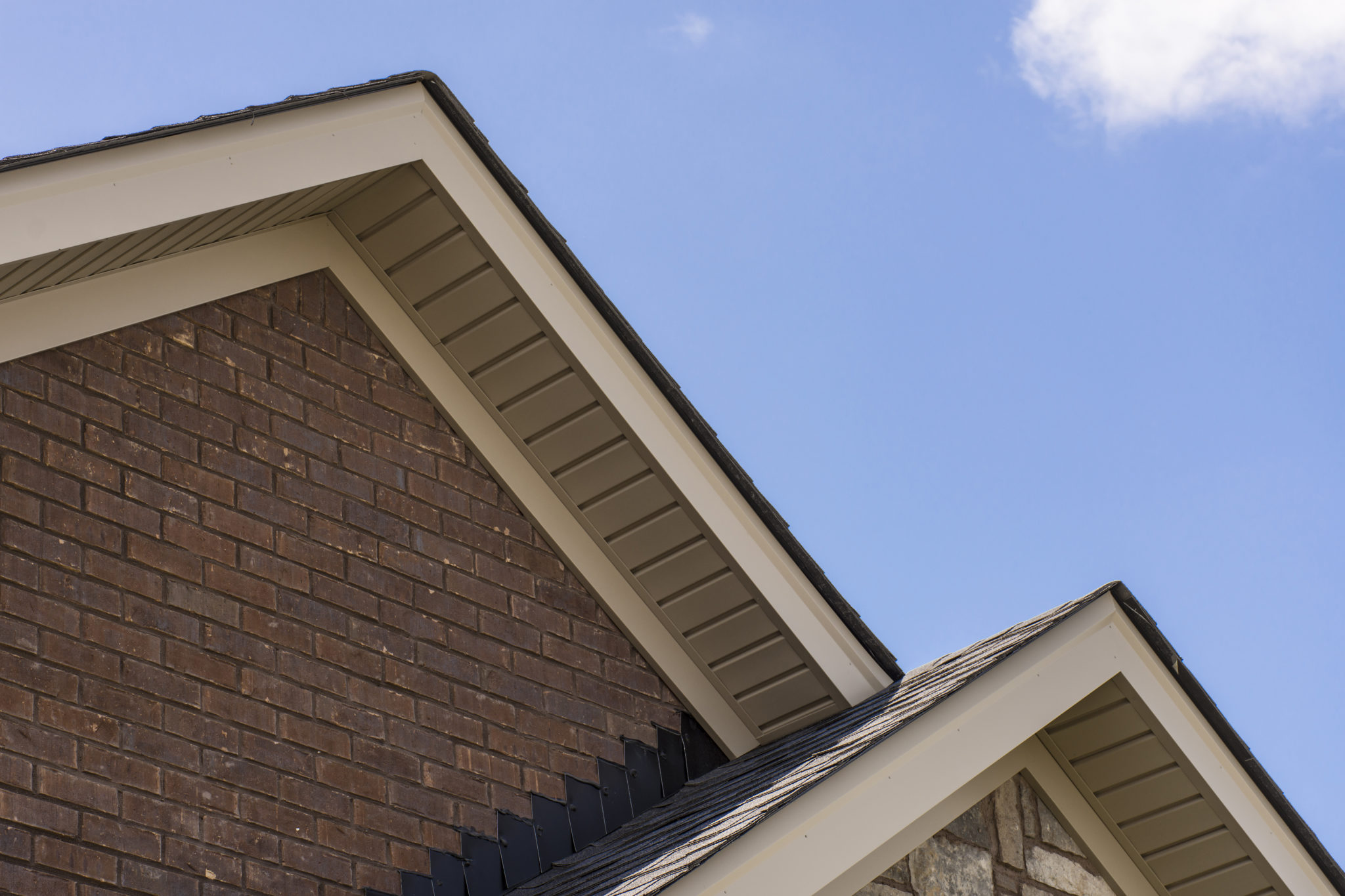 Roof showing soffit on the front of a brick and stone house.