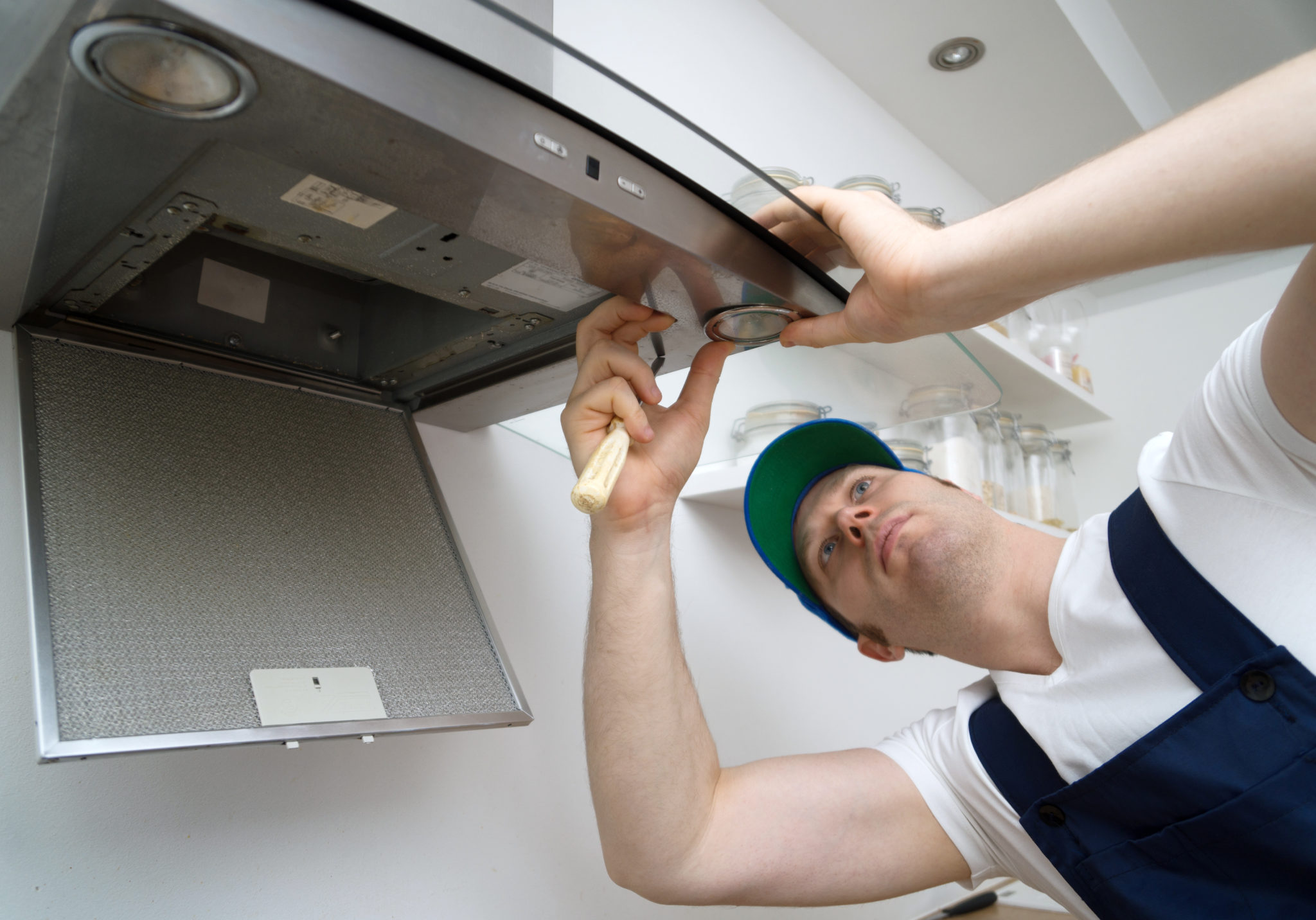 Man fixing kitchen exhaust hood that leads to the Exhaust Vent on the roof