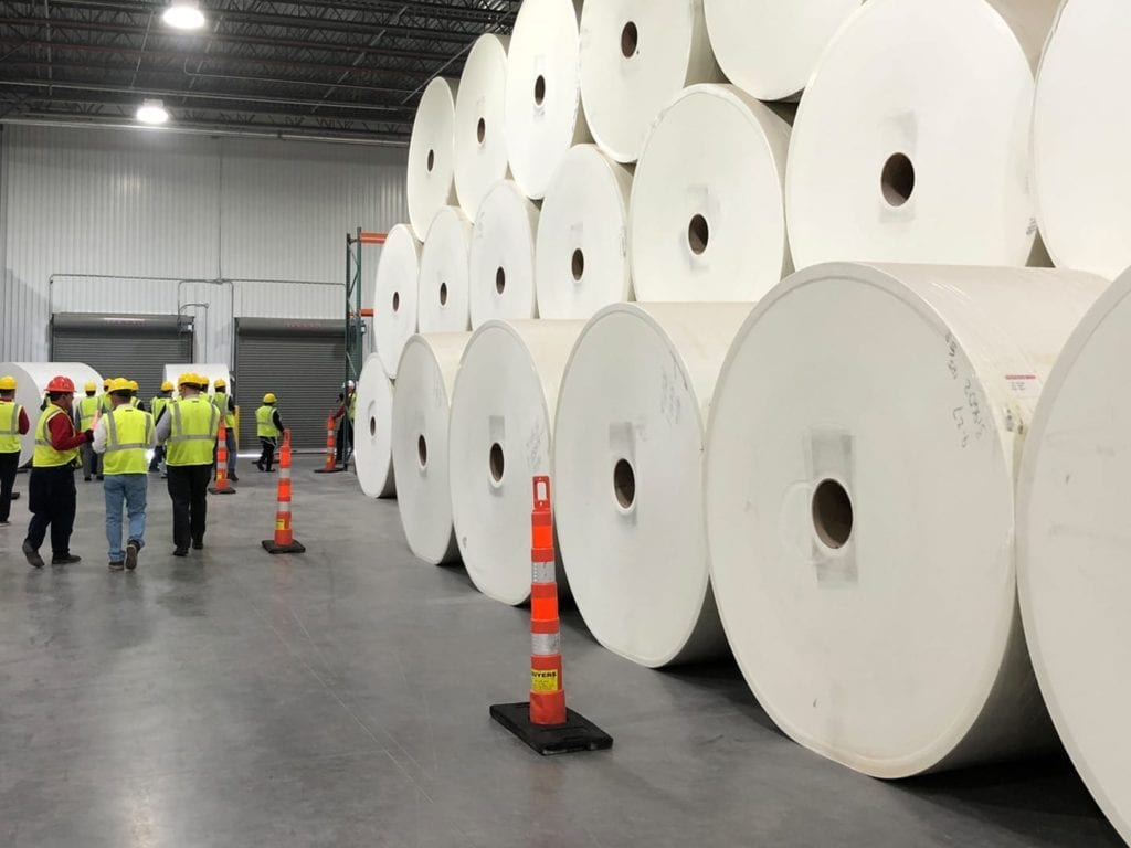 factory tour group passing fiberglass rolls