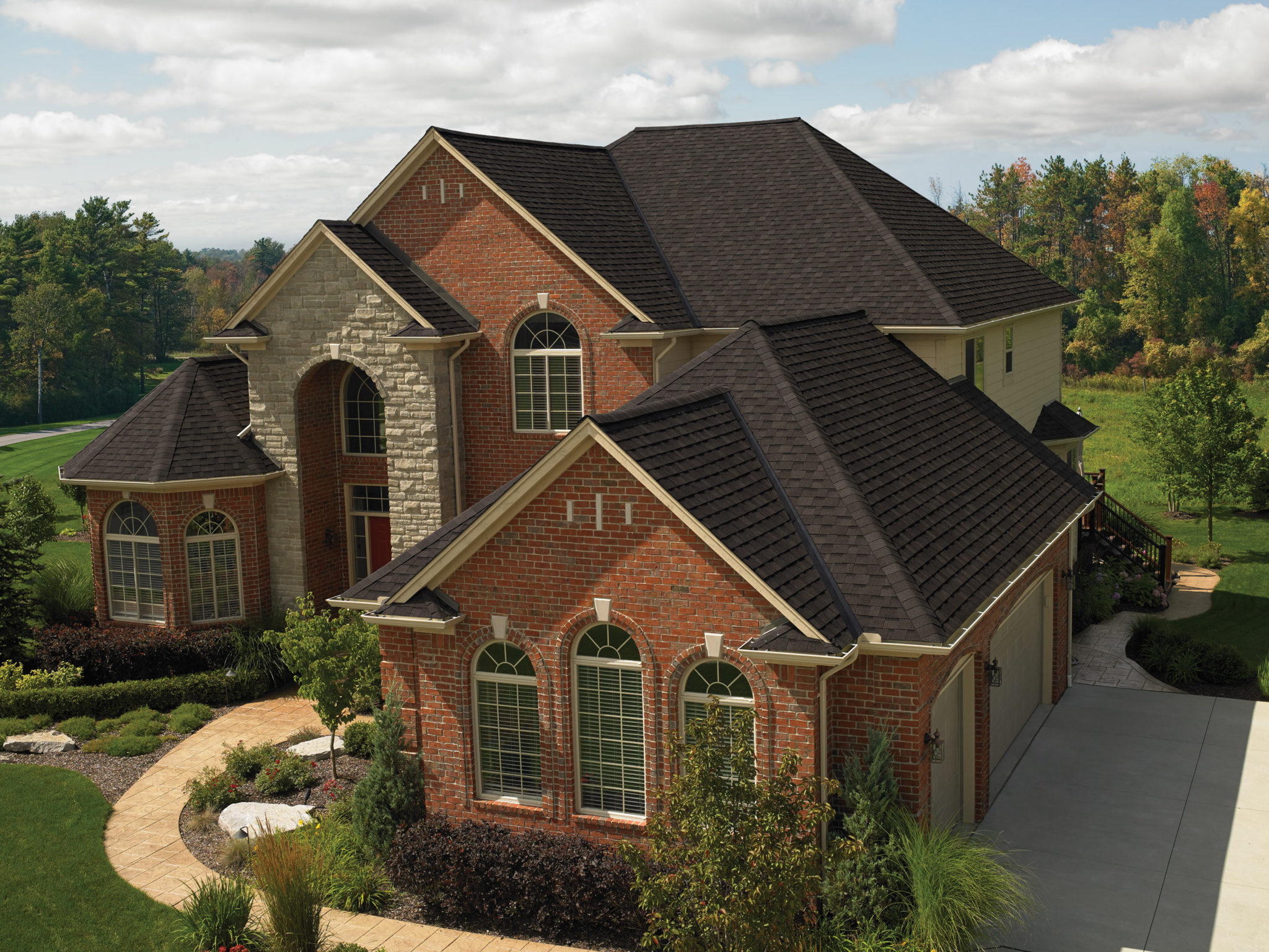 smoky red brick house with dark brown-black roof shingles