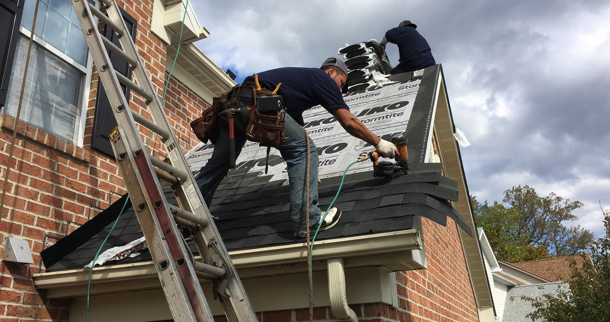  roofer shingling with a nail gun