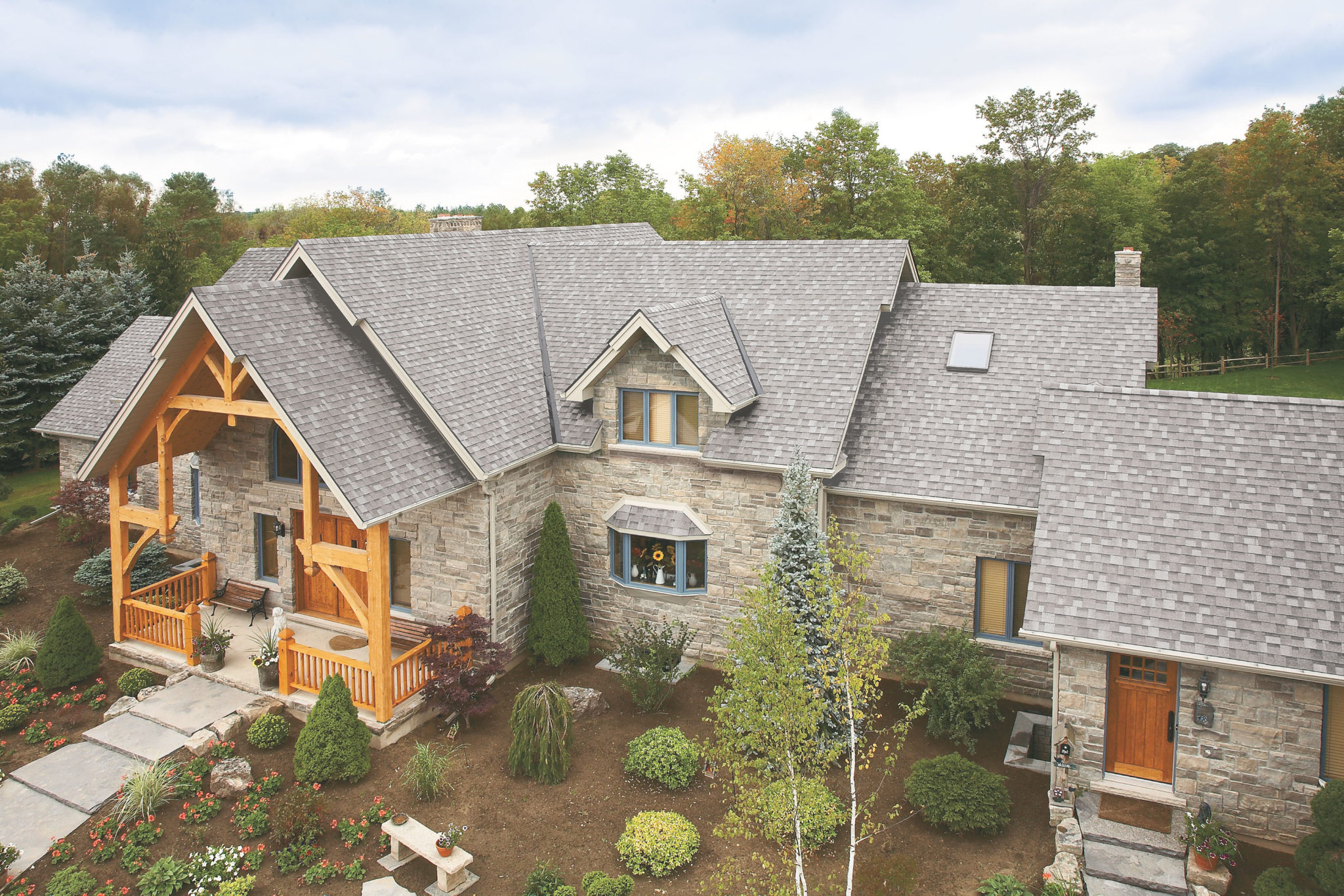 rural stone home with grey roof shingles