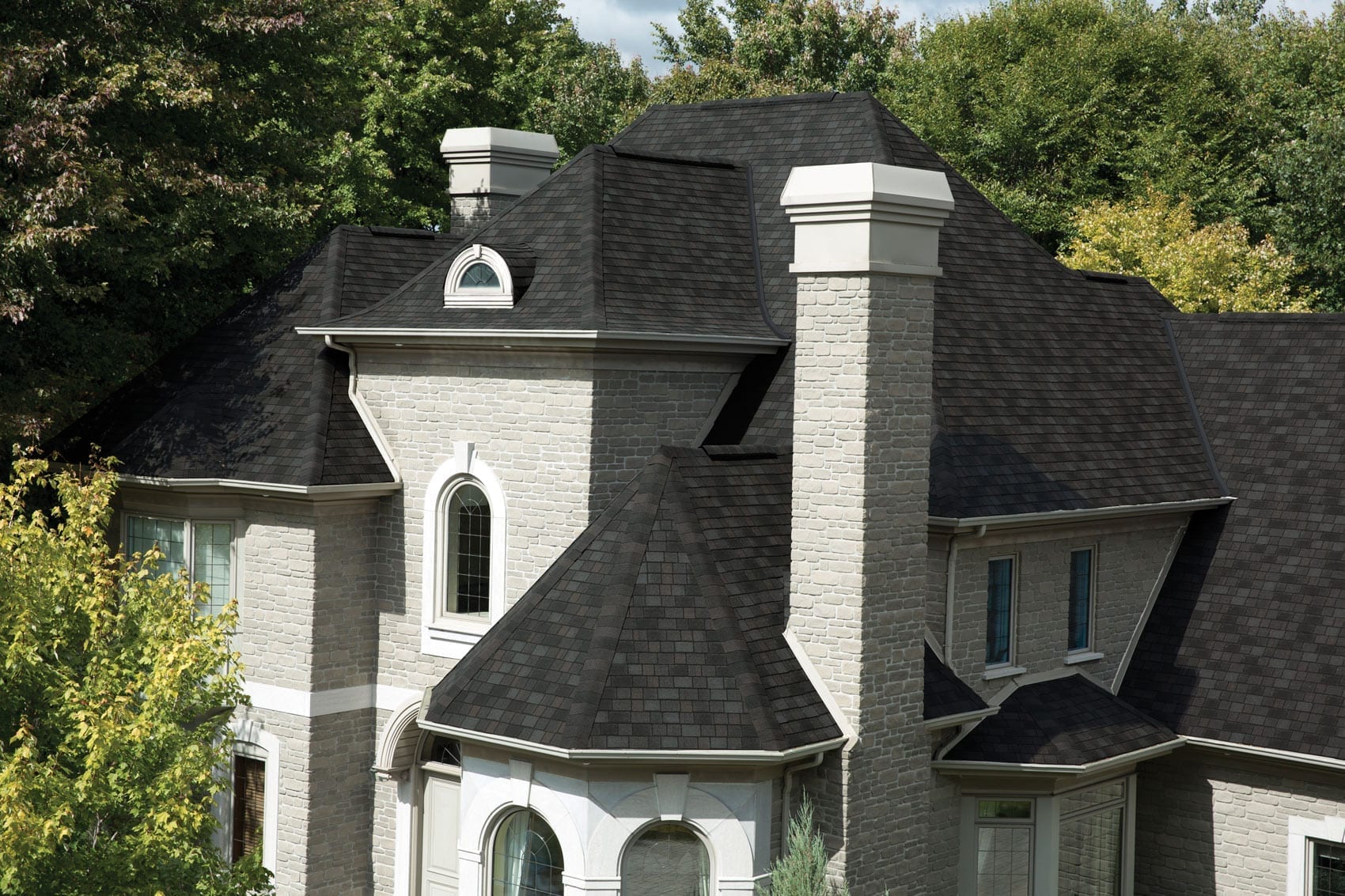 home with black roof shingles and chimney