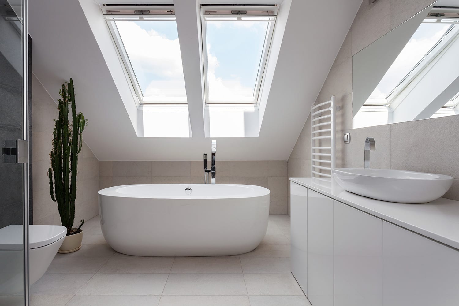 dos claraboyas en el techo de un baño blanco moderno