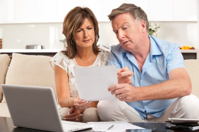 couple reviewing a document they have that shows when was the last time they had roof repair work done