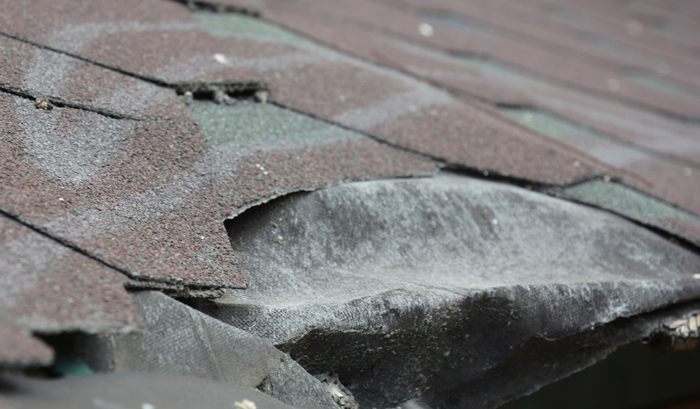 Damaged asphalt shingles roof damage