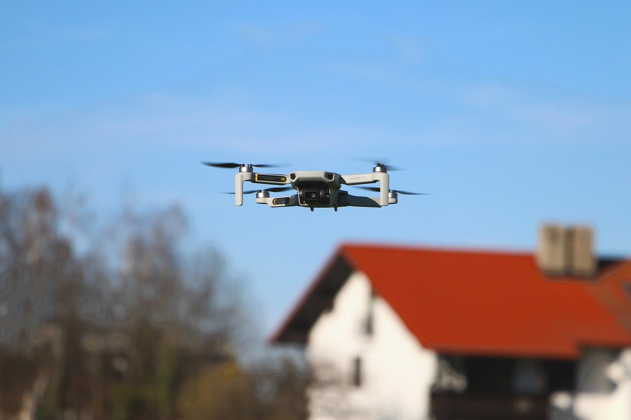 drone using camera to take aerial photos of homes' roofs