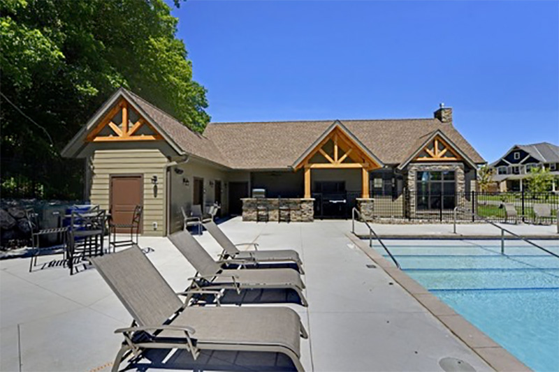 grey and brown roof shingle to match the wood beam accents and stone facing of this outdoor structure