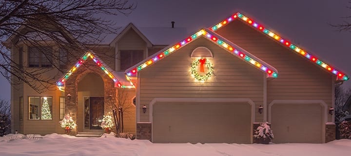 house lit up with color Xmas lights outline roof shape