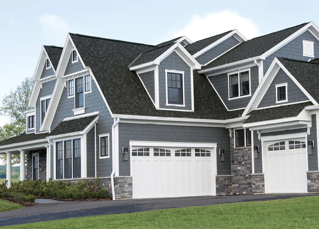 home and its garage covered with dark colored architecrual roof shingles