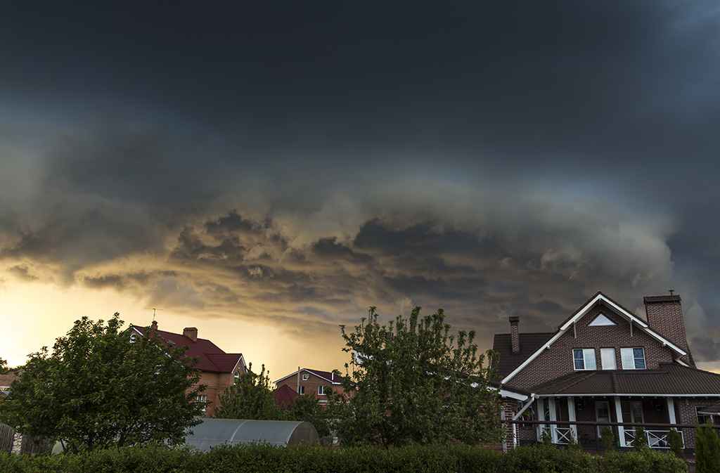 stormy sky over houses with shingle roofs