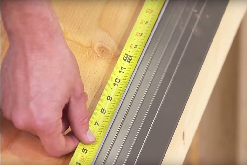 measuring a drip edge with a tape as part of installation process