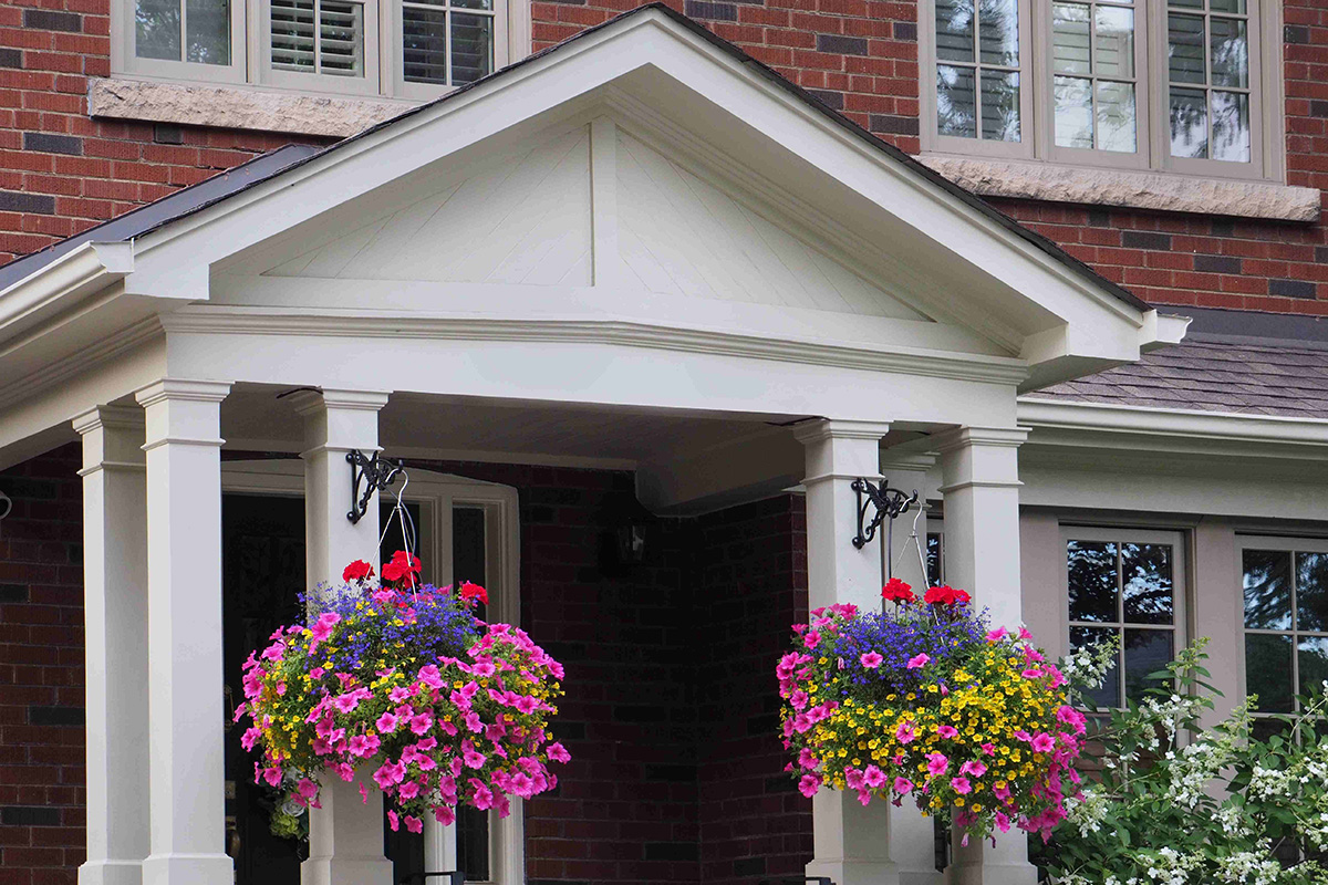 roof covered porch with hanging flower baskets