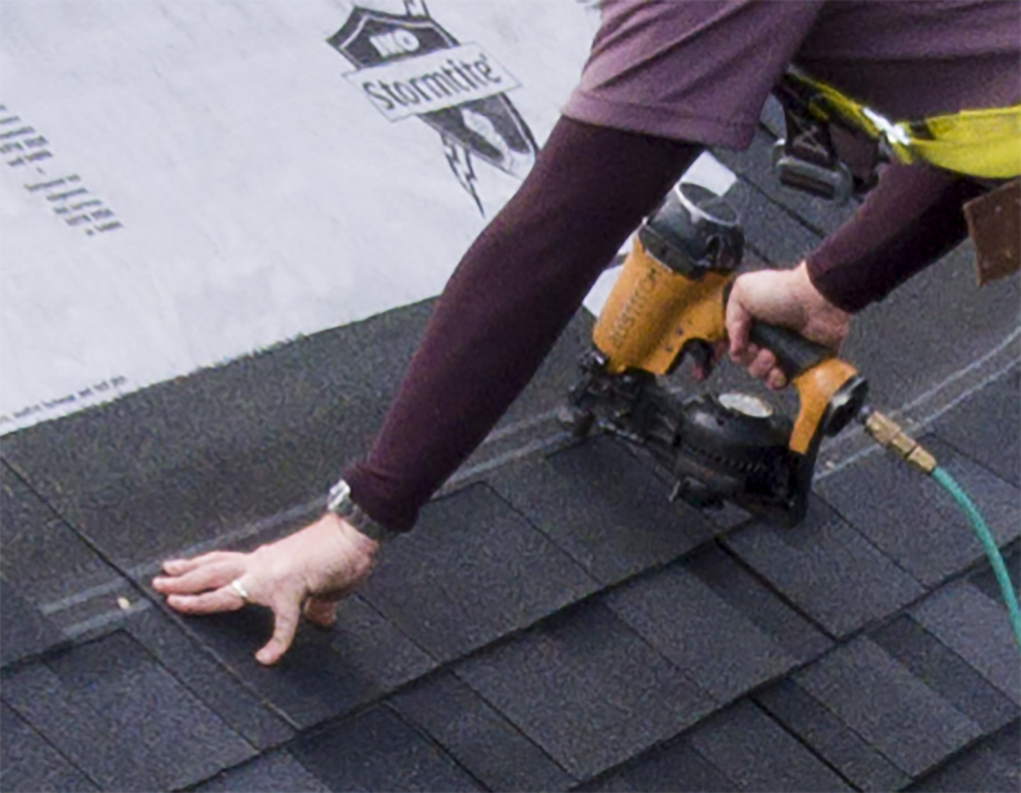 roofer nailing roof shingle
