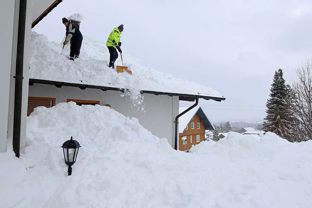 Roofers Shoveling Snow off Roof