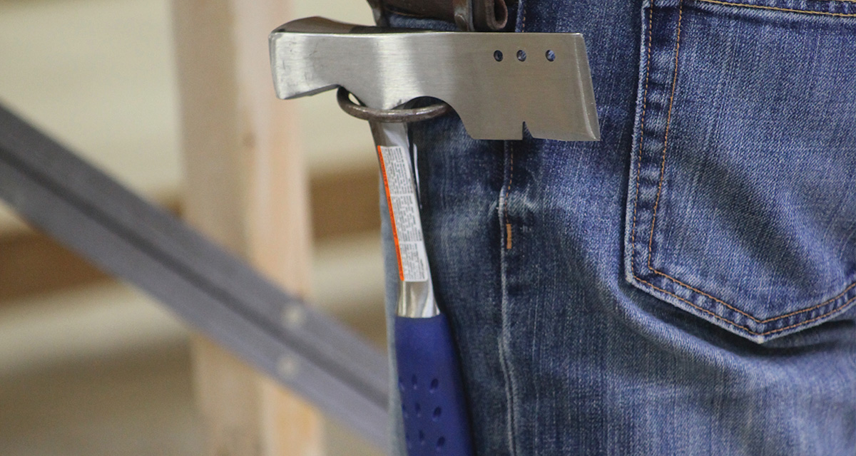 roofing hatchet hanging from roofer's belt