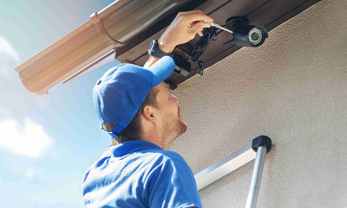 technician mounting home security camera to soffit